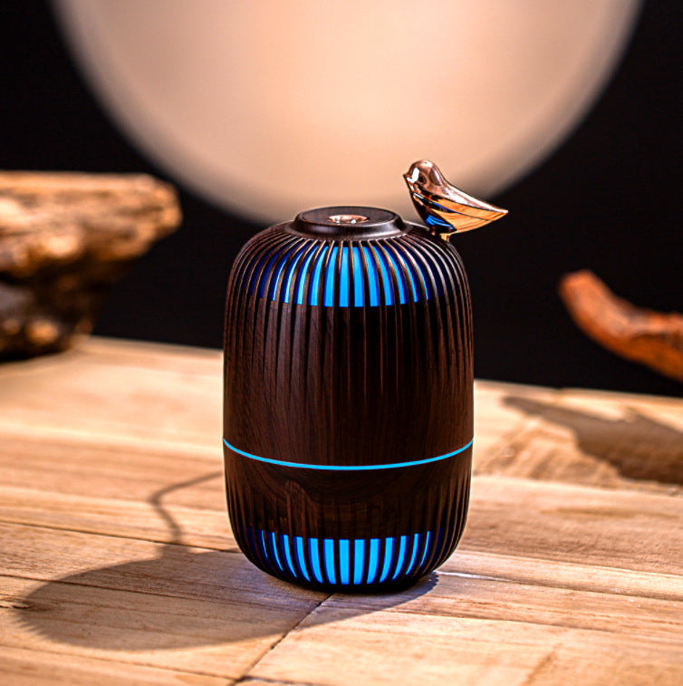 Dreambird Aroma Diffuser in Dark Walnut glowing blue